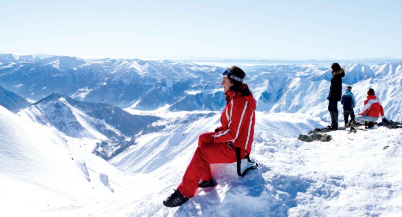 Beautiful woman on a snowy mountain peak